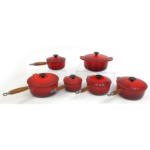 2315 - Group of Le Creuset red cast iron kitchenalia comprising graduated set of five lidded saucepans and ... 