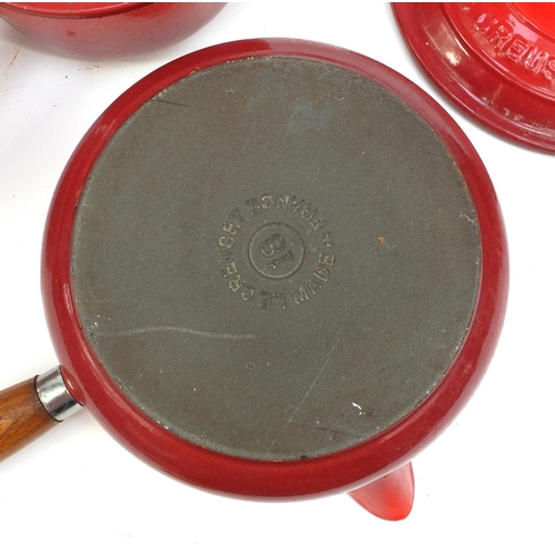 2315 - Group of Le Creuset red cast iron kitchenalia comprising graduated set of five lidded saucepans and ... 