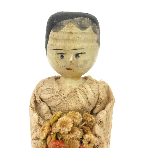 2292 - Antique hand painted wooden doll dressed in a silk costume holding a bunch of flowers, 31cm high