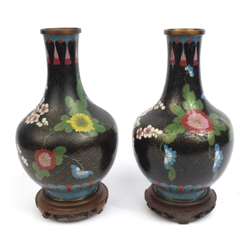 2174 - Pair of Chinese cloisonné vases decorated with flowers, both on hardwood stands, each vase 30cm high