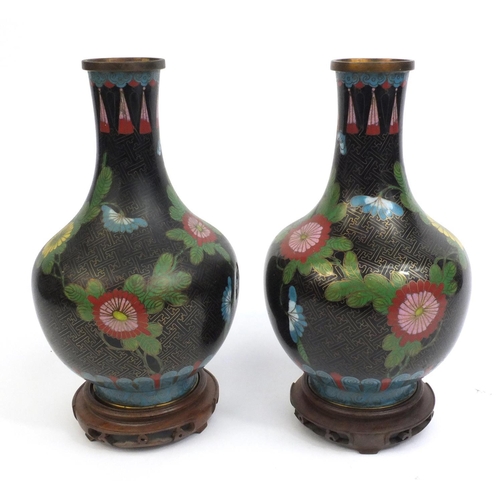 2174 - Pair of Chinese cloisonné vases decorated with flowers, both on hardwood stands, each vase 30cm high