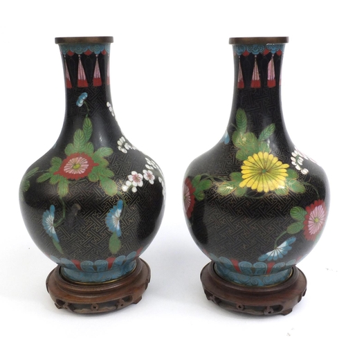 2174 - Pair of Chinese cloisonné vases decorated with flowers, both on hardwood stands, each vase 30cm high