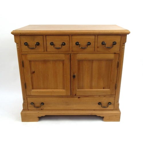 2034 - Pine side cabinet fitted with four drawers above a pair of cupboard doors and a further long drawer,... 