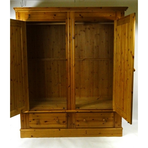 29 - Large pine two door wardrobe fitted with drawers to the base, 202cm high x 170cm wide x 58cm deep