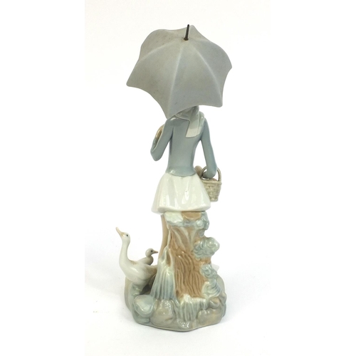 2103 - Lladro figurine of a girl holding an umbrella surrounded by four geese, factory marks to the base, 2... 