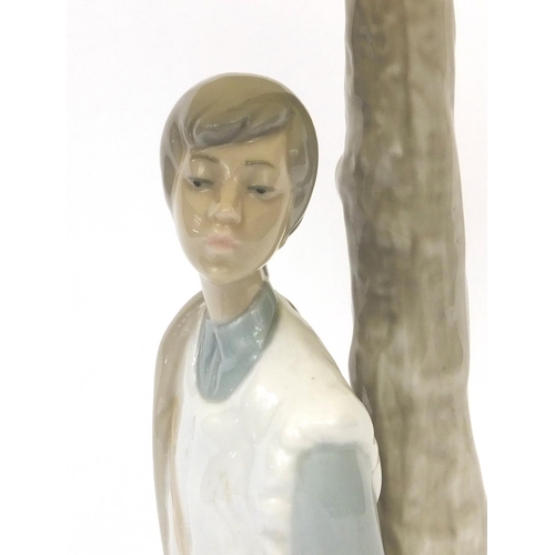 2090A - Nao porcelain table lamp and shade modelled as a seated boy