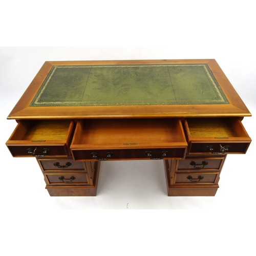 2002 - Yew wood twin pedestal desk with tooled leather top above an arrangement of nine drawers, 79cm high ... 
