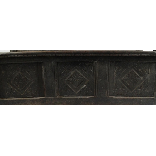 31 - Antique oak panelled settle with carved decoration and lift up seat, 142cm high x 152cm wide x 66cm ... 