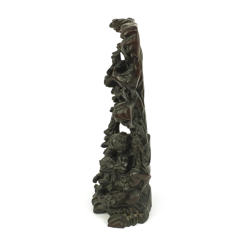 815 - Chinese hardwood root carving of two figures standing upon a tree, paper label to the base, 43cm hig... 