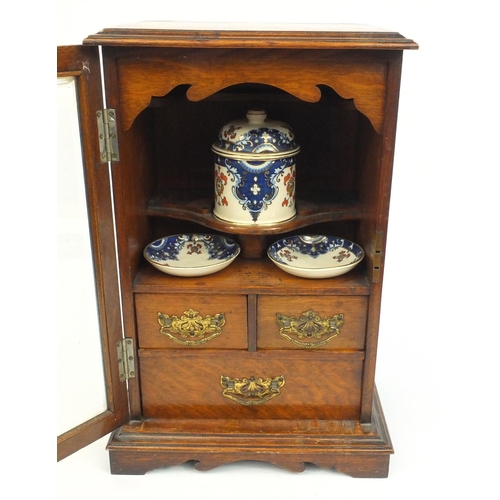 335 - Edwardian oak smokers cabinet, the bevelled glass door opening to reveal a fitted interior, 43cm x 2... 