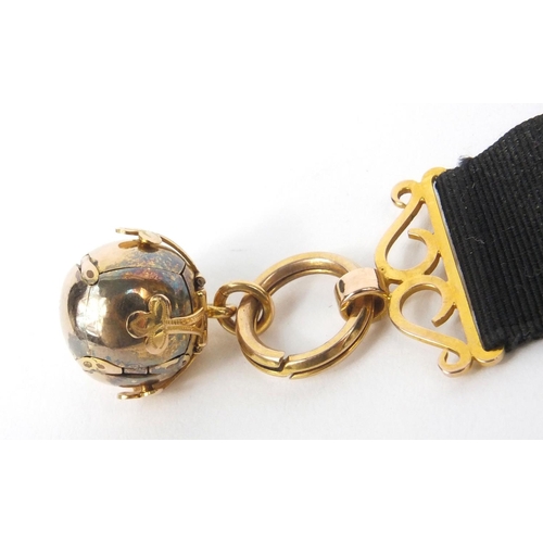 478 - * DESCRIPTION AMENDED 8/11 * 9ct gold cased Masonic puzzle ball jewel on ribbon, the puzzle ball ope... 