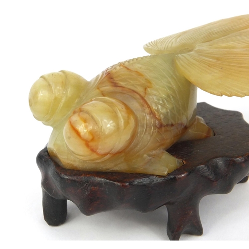 824 - Chinese jade goldfish raised on a hardwood base, 16cm long