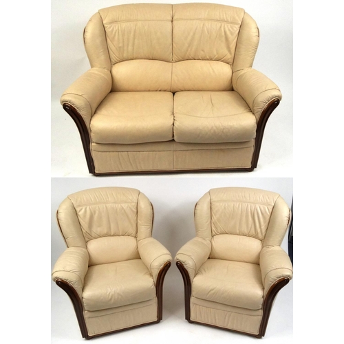 2025 - Italian cream leather three piece suite with polished wooden trim, comprising two seater settee and ... 