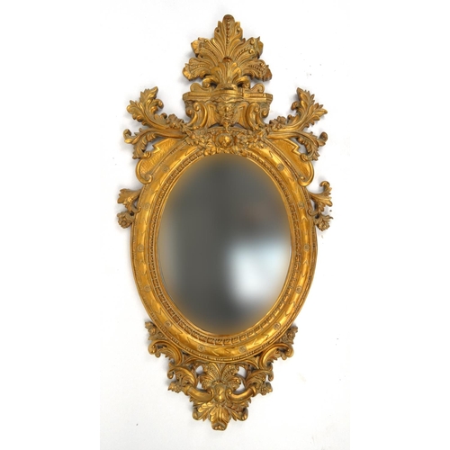 2006 - Large gilt oval mirror decorated with a grotesque masks, C scrolls and leaves, 174cm high