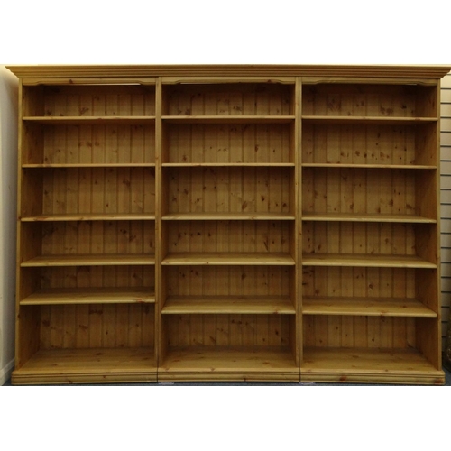 24 - Large pine three section bookcase fitted with adjustable shelves, 190cm high x 255cm wide x 32cm dee... 