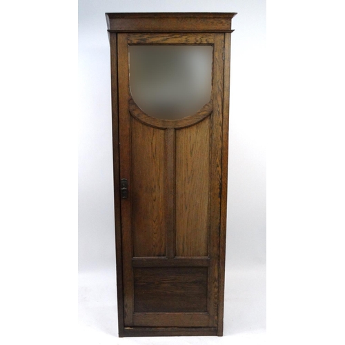 31 - Oak hall cupboard the door fitted with a bevelled mirror, 186cm high x 63cm wide x 41cm deep