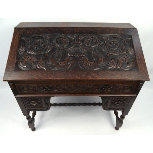 5 - Oak bureau the fall carved with dolphins and shells amongst foliage enclosing a fitted interior abov... 