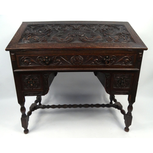 5 - Oak bureau the fall carved with dolphins and shells amongst foliage enclosing a fitted interior abov... 