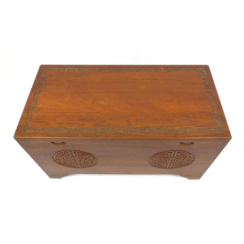 2051 - Oriental camphor wood chest carved with stylised roundels, 56cm high x 102cm wide x 50cm deep
