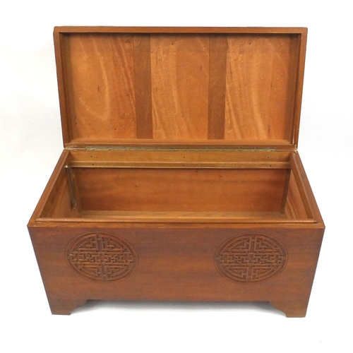 2051 - Oriental camphor wood chest carved with stylised roundels, 56cm high x 102cm wide x 50cm deep