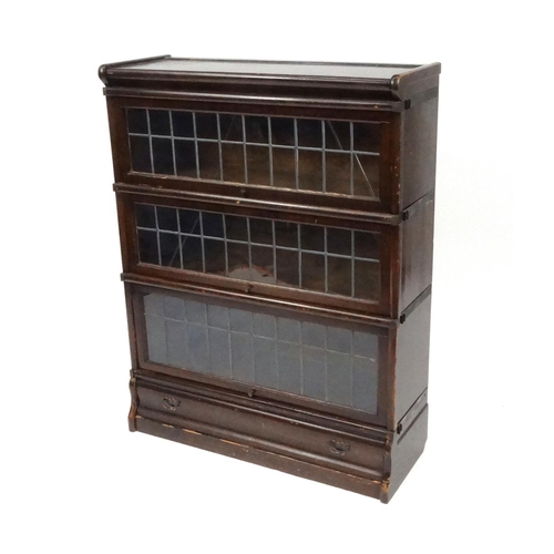 2007 - Globe Wernicke oak three section bookcase with lead glazed doors and drawer to the base, 105cm high ... 