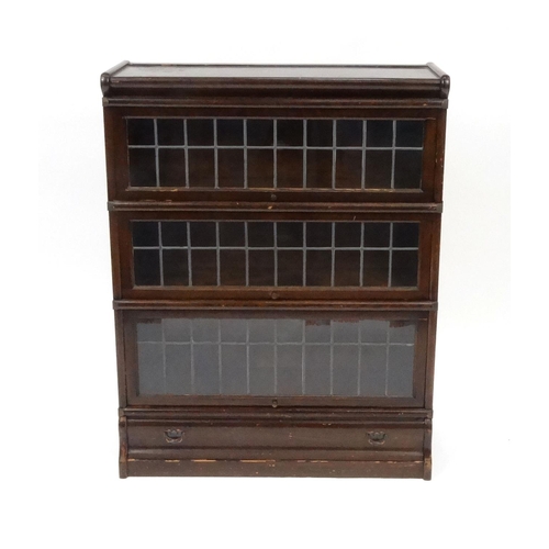 2007 - Globe Wernicke oak three section bookcase with lead glazed doors and drawer to the base, 105cm high ... 