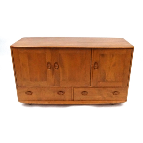 2062 - Ercol light elm Windsor sideboard fitted with three cupboard doors above two drawers, on castors, 76... 