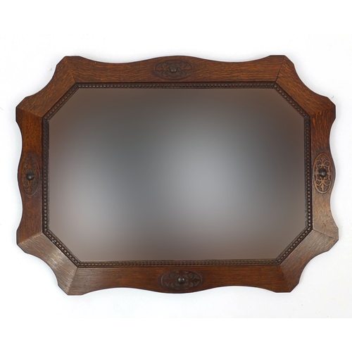 2035 - Ornately carved oak framed bevelled edge mirror, 90cm wide