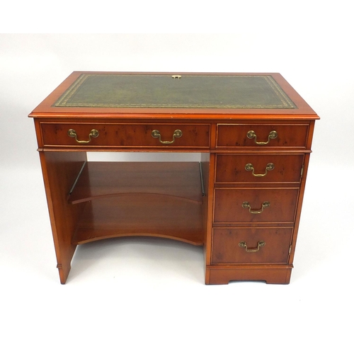 69 - Yew wood desk with tooled leather top, fitted with two drawers above a cupboard door and slide out s... 