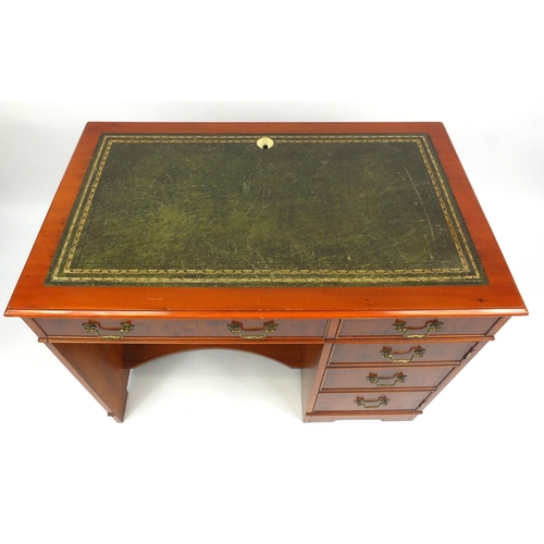 69 - Yew wood desk with tooled leather top, fitted with two drawers above a cupboard door and slide out s... 