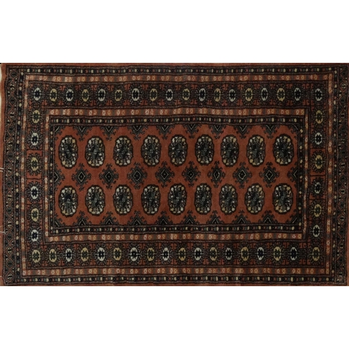 106 - Three Salmon ground geometric patterned rugs, the larger 155cm x 95cm