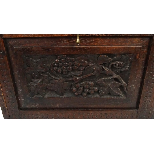49 - Carved oak cupboard with grapevine design front panel and shelved interior, 66cm high x 58cm wide x ... 