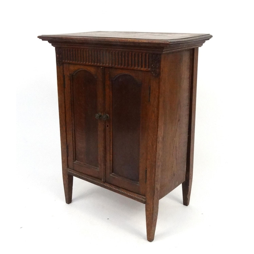 83 - Carved oak two door side cabinet, 74cm high x 57cm wide x 35cm deep