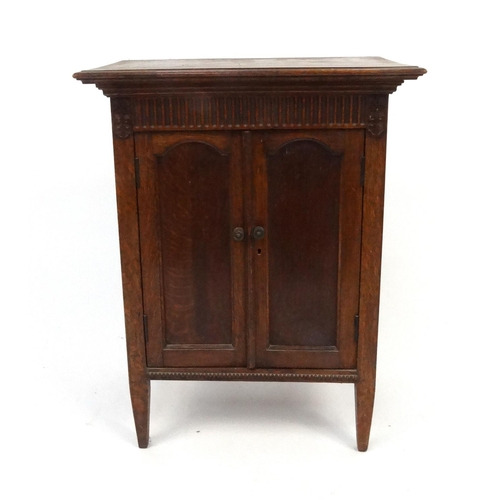 83 - Carved oak two door side cabinet, 74cm high x 57cm wide x 35cm deep