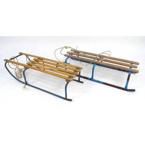 157 - Two vintage wooden and metal sleighs, the larger 96cm long