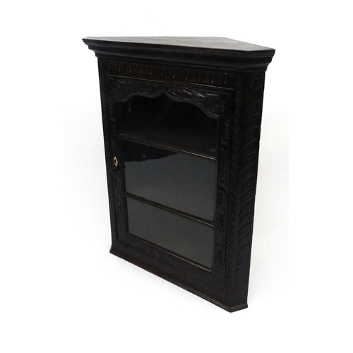 116 - Carved oak hanging corner cabinet with glazed door, 93cm high x 75cm wide x 38cm deep