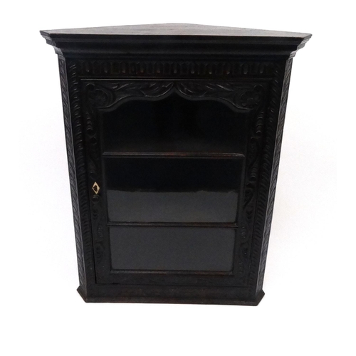 116 - Carved oak hanging corner cabinet with glazed door, 93cm high x 75cm wide x 38cm deep