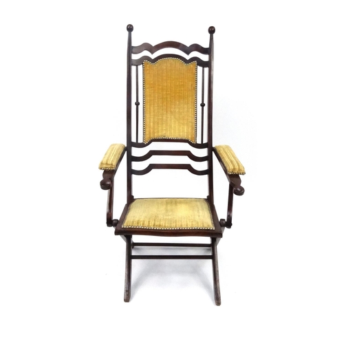 6 - Folding mahogany armchair with gold upholstered back, seat and arms