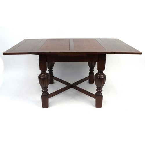 88 - Oak draw leaf dining table and four chairs with leatherette backs and seats