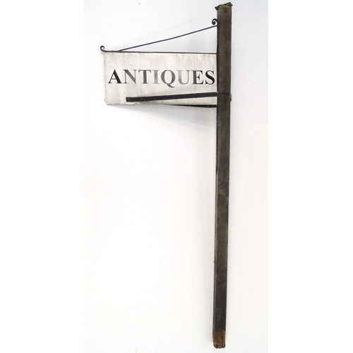 109 - An antique's shop sign on wooden post, the sign 67cm x 30cm