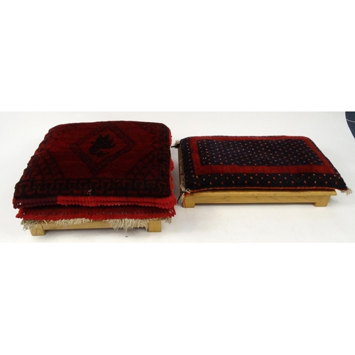 128 - Two North African low seats with burgundy upholstered cushions,