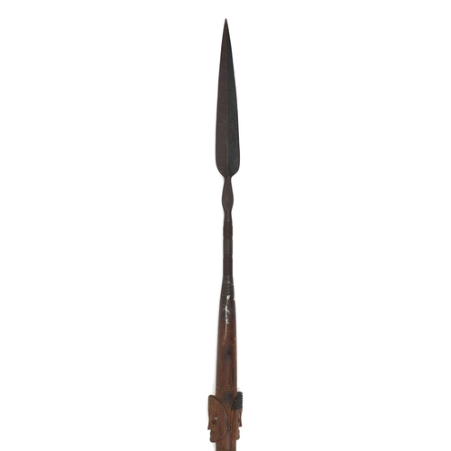 328 - African hardwood ceremonial spear carved in relief with face masks, 208cm long