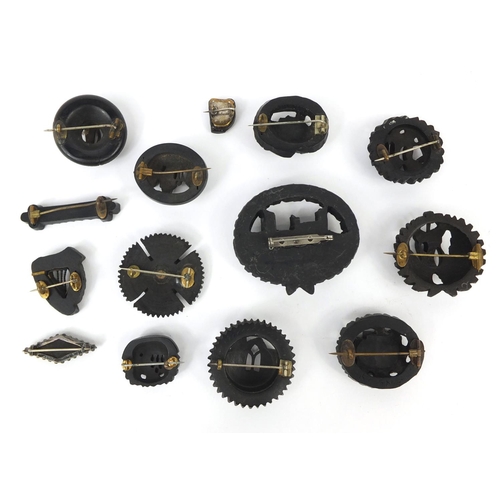 14 - Collection of Irish Bog oak brooches including examples carved with castles and harps together with ... 