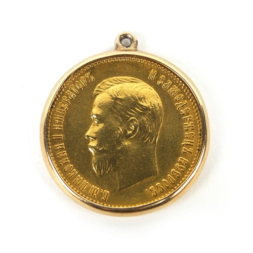 252 - Nicholas II 1903 ten rouble gold coin, housed in a gold coloured metal pendant mount, approximately ... 