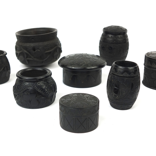 6 - Collection of Irish Bog oak comprising of pots and covers and barrel shaped pots, mostly decorated w... 