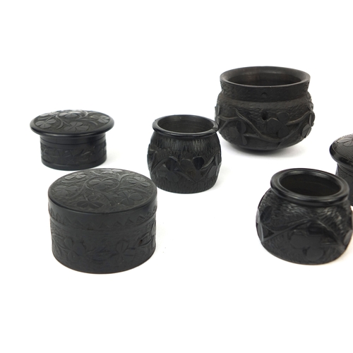 6 - Collection of Irish Bog oak comprising of pots and covers and barrel shaped pots, mostly decorated w... 