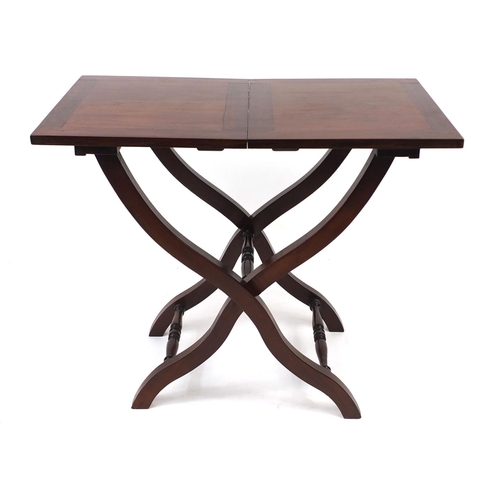 2025 - Folding mahogany campaign table with X frame legs, 69cm high x 82cm wide x 46cm deep