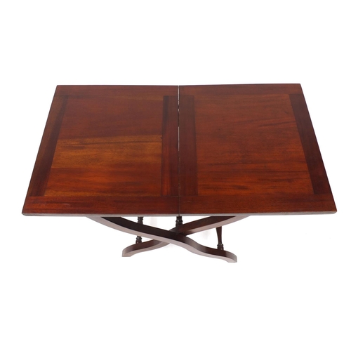 2025 - Folding mahogany campaign table with X frame legs, 69cm high x 82cm wide x 46cm deep