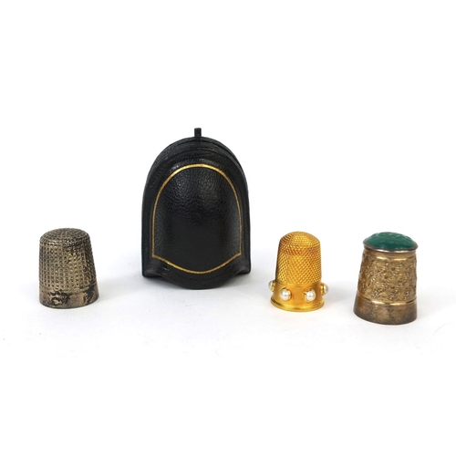 73 - Three thimbles comprising a gold coloured metal example set with six pearls housed in a Victorian ve... 