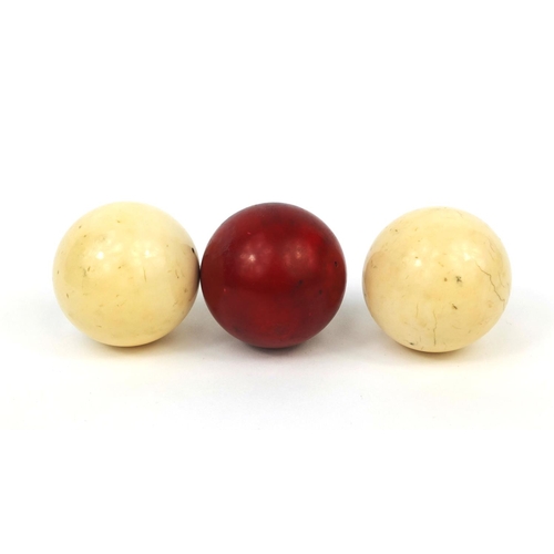 147 - Boxed set of three Victorian ivory billiard balls including a stained red example, together with ori... 